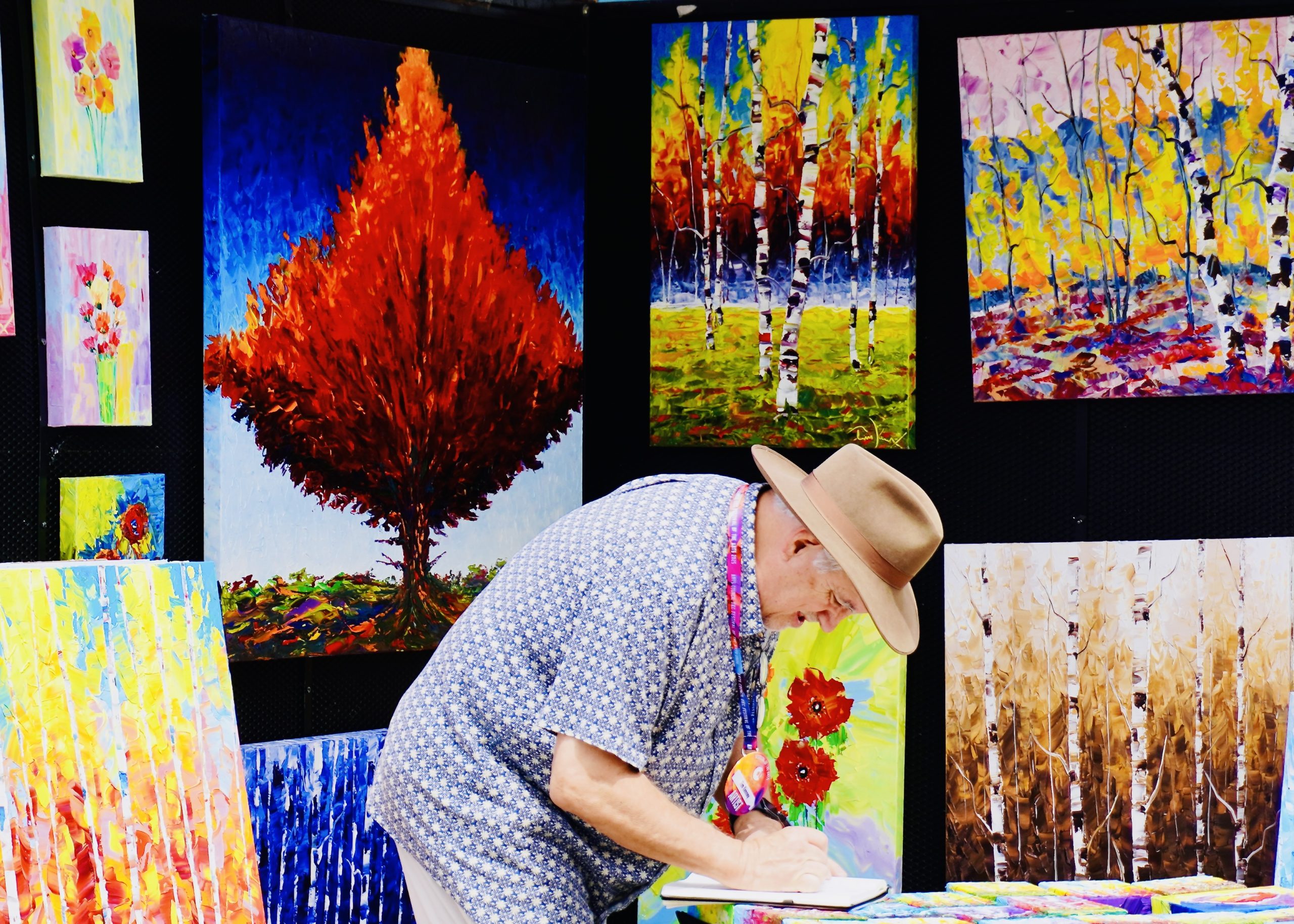 Tim Kenney finishes filling out paperwork after selling one of his paintings at the Festival of Arts in Oklahoma City. Photo and Video credit Karintha